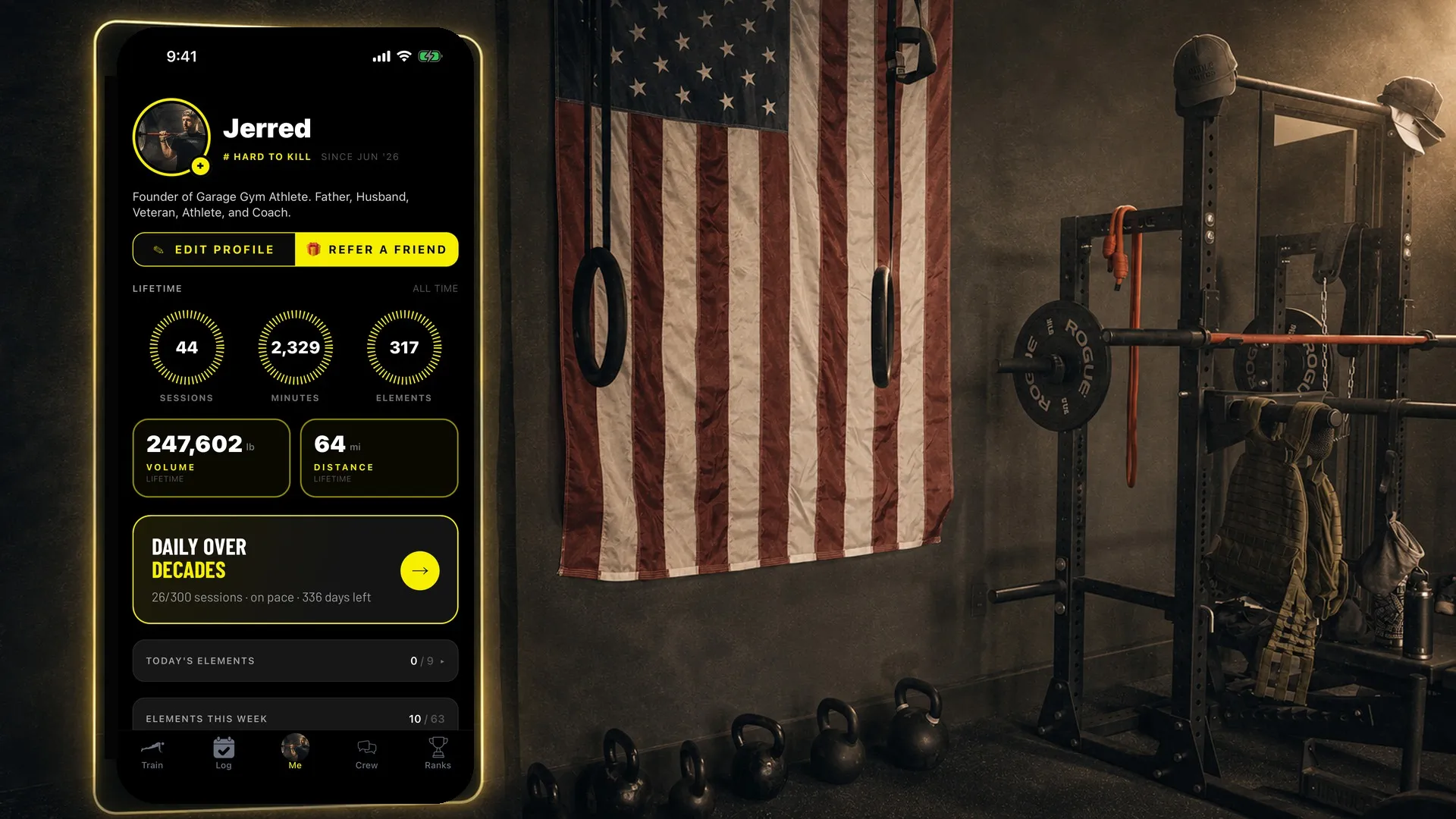 The Garage Gym Athlete app glowing on a phone in a garage gym with a flag, rings, and kettlebells