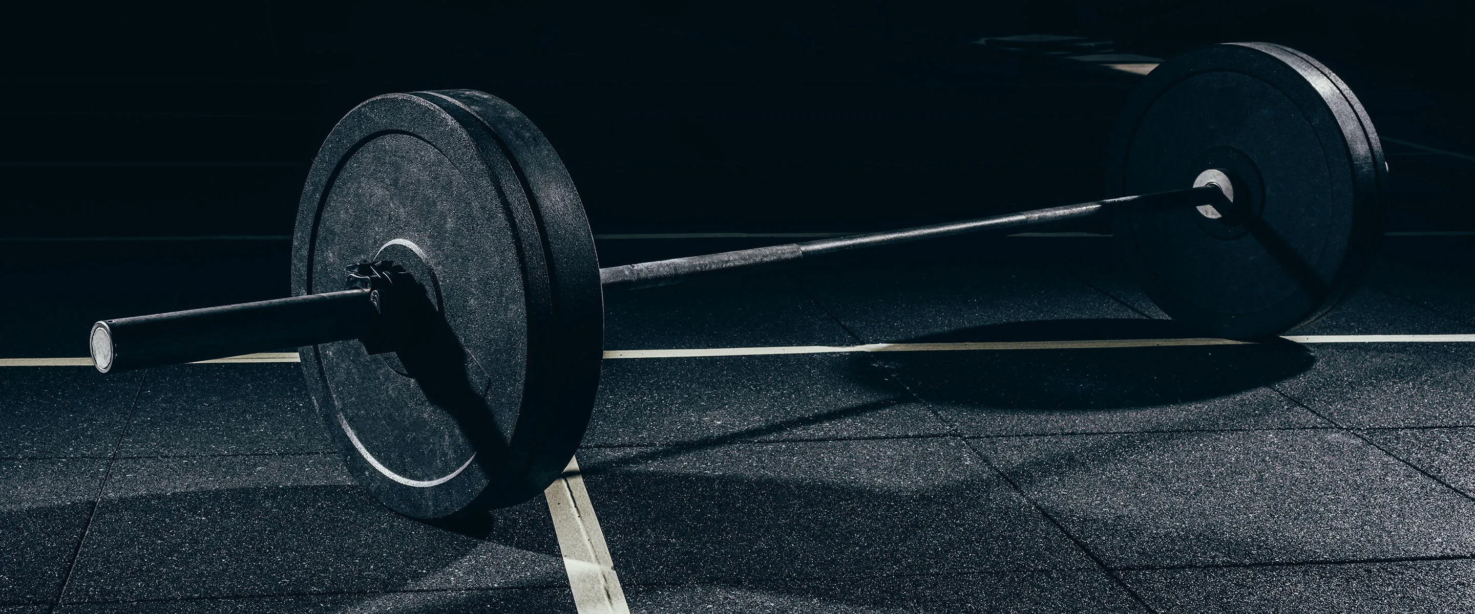 A loaded barbell resting on a gym floor